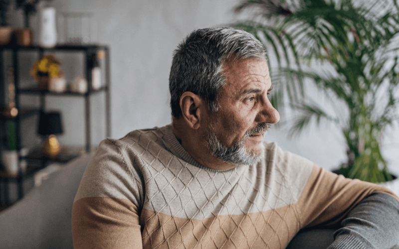 Man looking out the window from him sofa