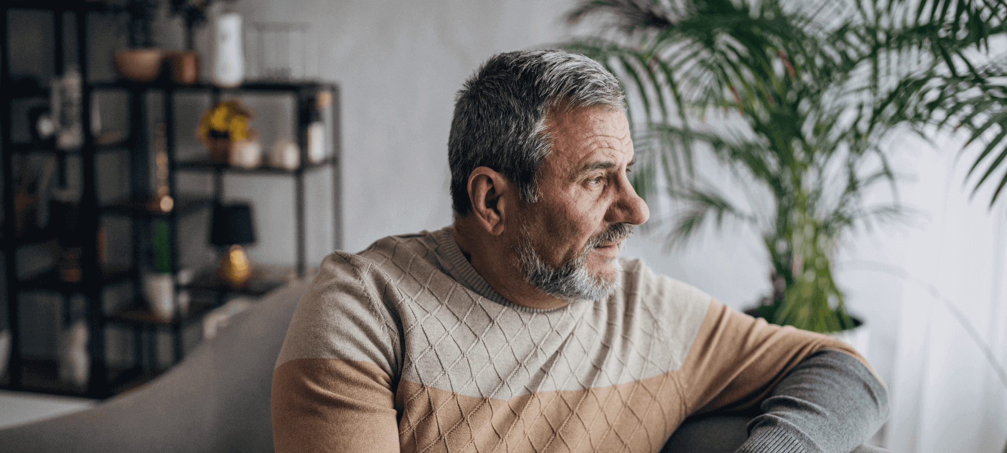 Man looking out the window from him sofa